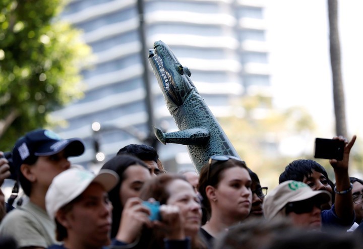 Los fanáticos sostienen un cocodrilo inflable. Foto: REUTERS
