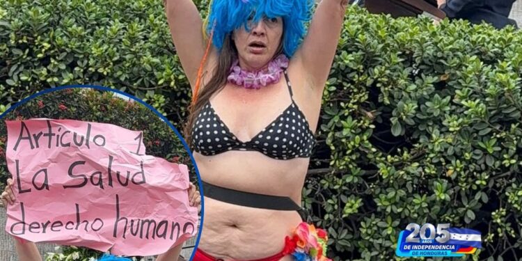 ¡En calzón y con pancarta! Mujer irrumpe en pleno acto patrio frente al BCIE y lanza fuerte reclamo por la salud